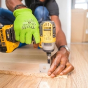 person-using-dewalt-cordless-impact-driver-on-brown-board